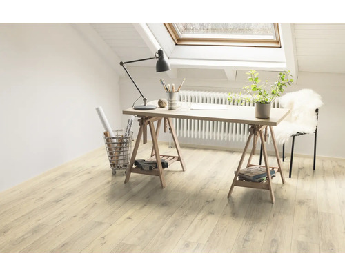 Ljus arbetsplats under ett takfönster med skrivbord på trägolv