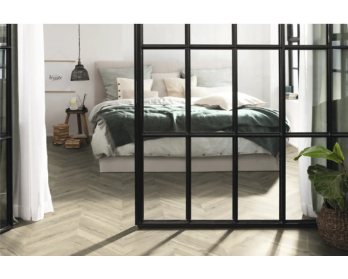 Ljust sovrum med säng, trägolv och rumsavdelare i fönsterstil