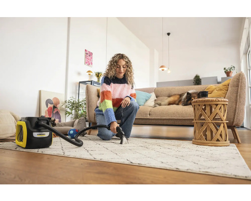 Kvinna rengör matta med Kärcher mattrengörare i ett ljust vardagsrum
