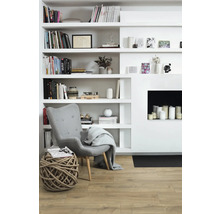 Vardagsrum med bokhylla, fåtölj och dekoration