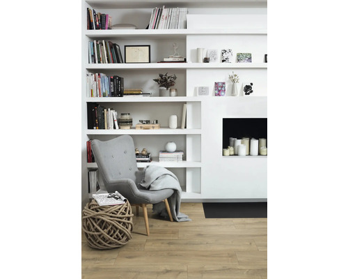 Vardagsrum med bokhylla, fåtölj och dekoration