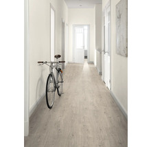 Hall med ljust laminatgolv, vita väggar och en cykel