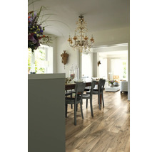 Matsal med trägolv, matbord, stolar och kristallkrona