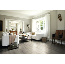 Ljust vardagsrum med soffa, bord och trägolv