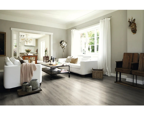 Ljust vardagsrum med soffa, bord och trägolv