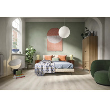 Sovrum med säng, skåp, fåtölj och dekorativa element för en mysig atmosfär