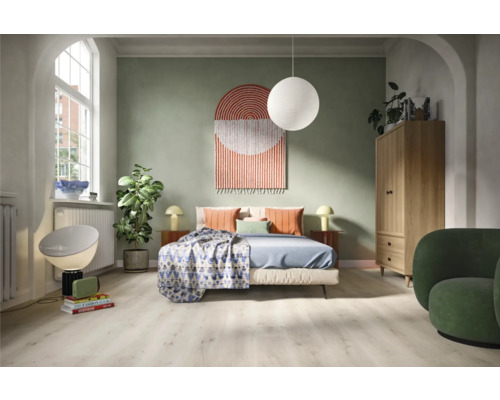 Sovrum med säng, skåp, fåtölj och dekorativa element för en mysig atmosfär