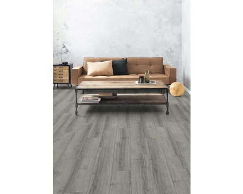 Vardagsrum med grått trägolv, soffa och soffbord