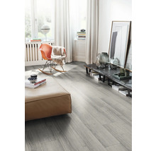 Vardagsrum med grått laminatgolv, pall och gungstol.