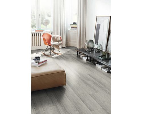 Vardagsrum med grått laminatgolv, pall och gungstol.