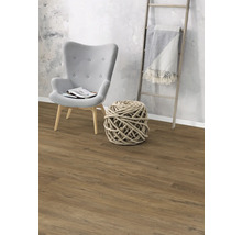 Vardagsrum med fåtölj, dekorativ repkula, stege och laminatgolv.