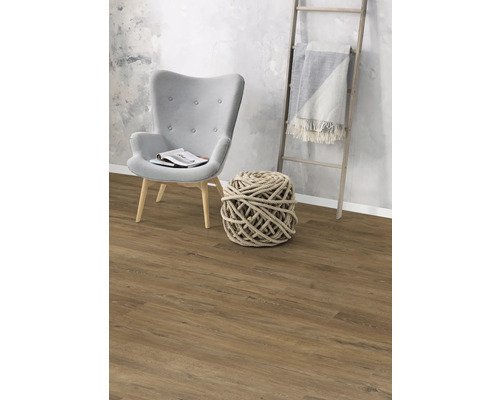 Vardagsrum med fåtölj, dekorativ repkula, stege och laminatgolv.