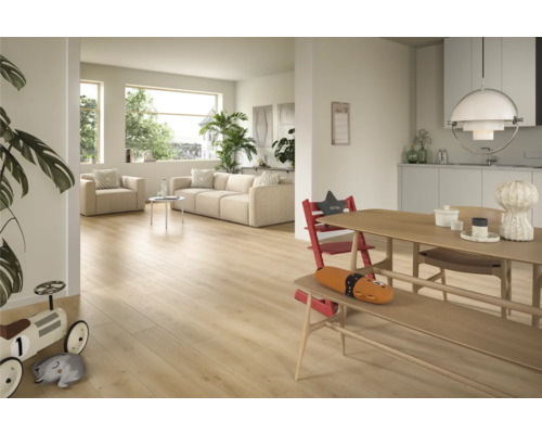 Ljust vardagsrum med trägolv, soffa och matplats.