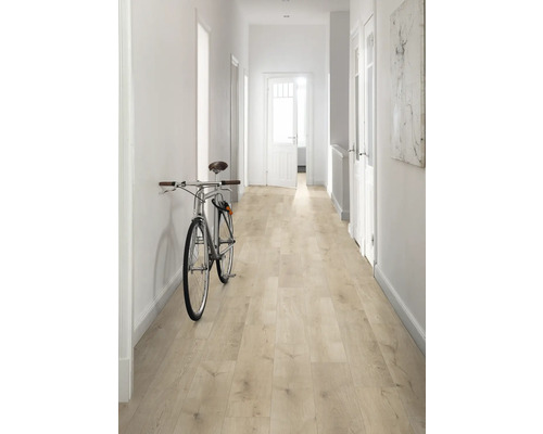 Hall med ljust trägolv, vita väggar och en cykel