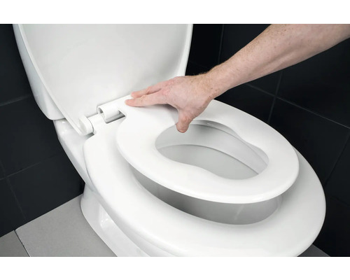 Toalett med toalettlock och hand som rör sitsen