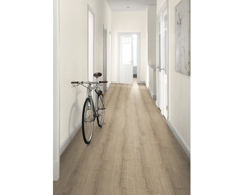 Hall med laminatgolv, vita väggar och en cykel