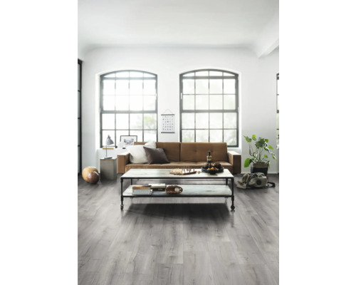 Vardagsrum med soffa, bord och ljust trägolv