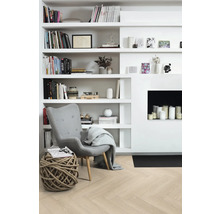 Vardagsrum med bokhylla, fåtölj och dekoration