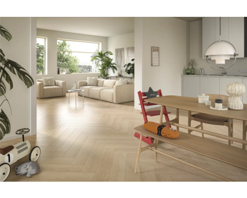 Ljust vardagsrum med fiskbensparkett, soffa, fåtölj och matbord med barnstol