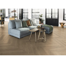 Vardagsrum med fiskbensparkettgolv, soffa och träbord.