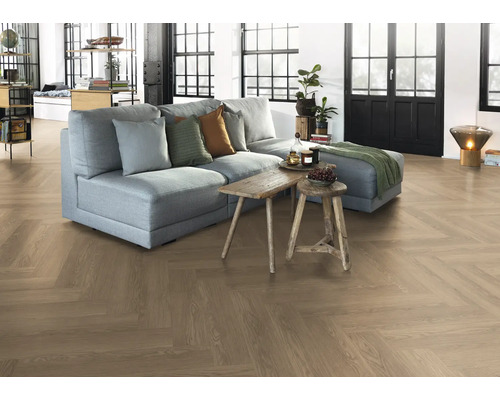 Vardagsrum med fiskbensparkettgolv, soffa och träbord.