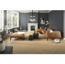 Vardagsrum med fiskbensparkett, skinnsoffa och öppen spis