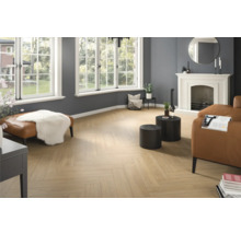 Vardagsrum med fiskbensparkett, öppen spis och sittmöbler