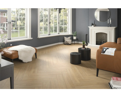 Vardagsrum med fiskbensparkett, öppen spis och sittmöbler