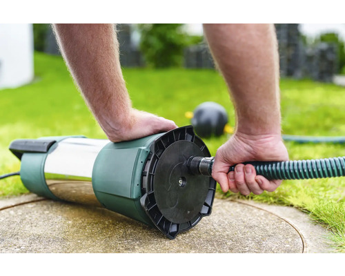 Djupbrunnspump ansluts till en vattenslang.