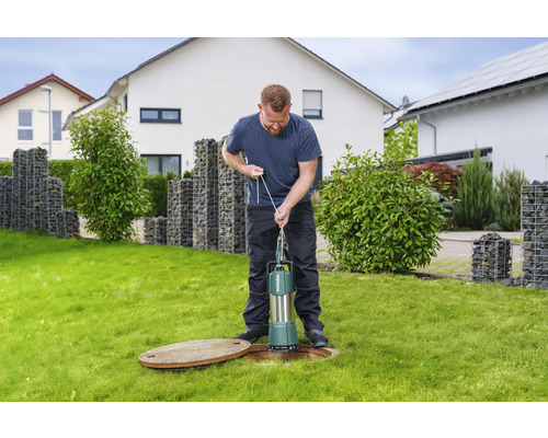 Man använder en Metabo dränkpump på en gräsmatta