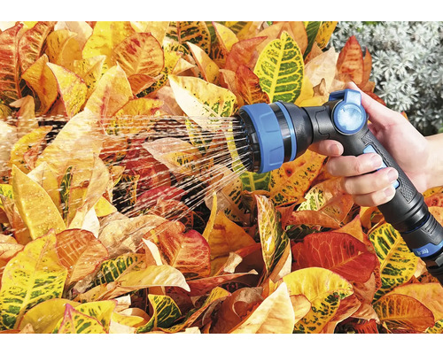 En person vattnar växter med en trädgårdsspruta.