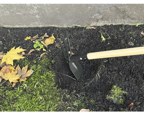 Trädgårdshacka med träskaft i rabatten