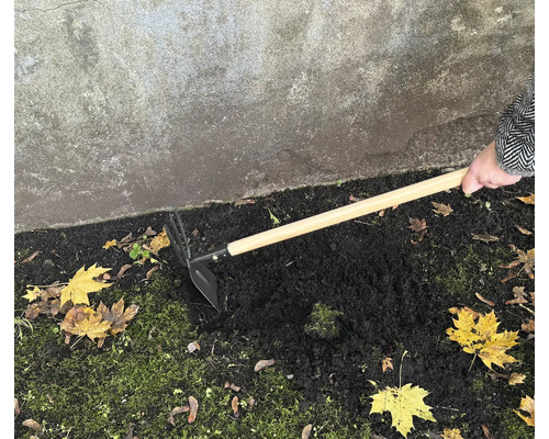 Trädgårdshacka med trähandtag som används för att luckra upp jorden