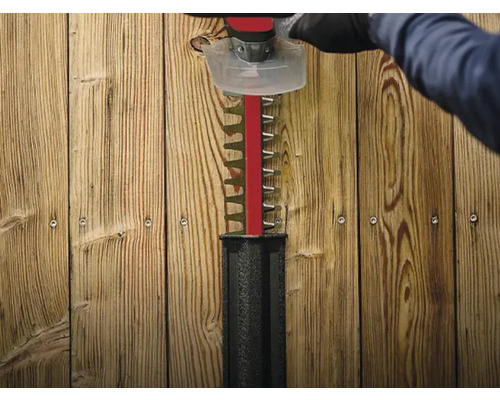 Häcksax i drift framför trävägg