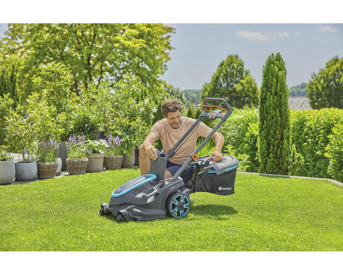 Man förbereder Gardena batteridriven gräsklippare för gräsmattavård i trädgården