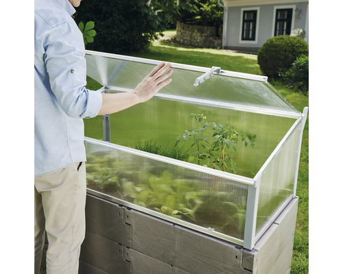 Hög odlingsbädd med odlingskrage och person i trädgården.