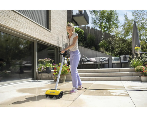 Kvinna rengör terrass med ytrengöringsmaskin