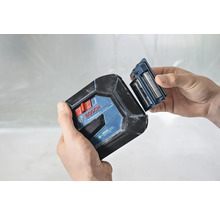 Bosch logotyp. En person byter batterierna på en krysslaser.