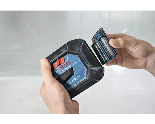 Bosch logotyp. En person byter batterierna på en krysslaser.