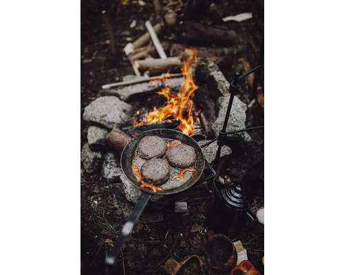 Stekpanna med hamburgare över en lägereld