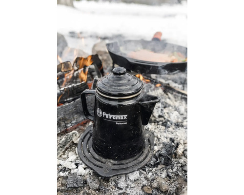 Petromax perkolatorkaffekanna på ett grillgaller över en lägereld.