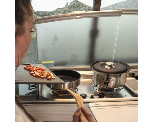 Matlagning i en husbil med ingredienser på en skärbräda bredvid spisen