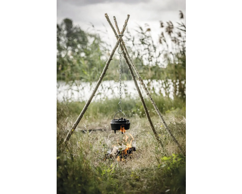 Trefotsgrillplats med holländsk ugn över öppen eld utomhus.