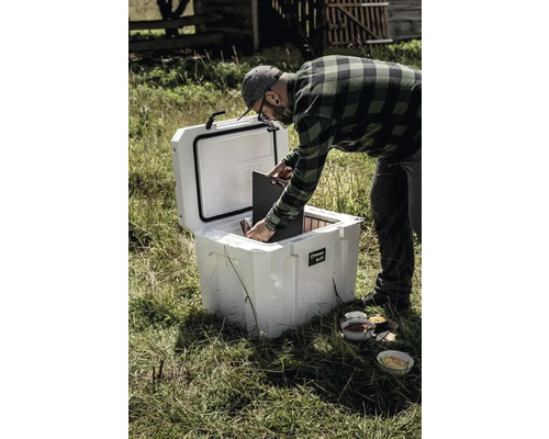 Man fyller en Perovskite kylbox utomhus.