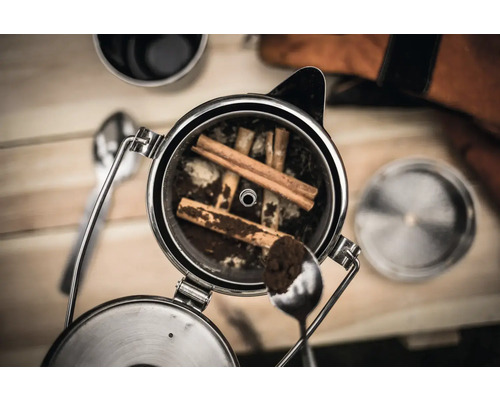 Kaffepress med kaffepulver och kanelstänger
