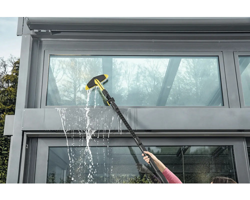 Fönsterrengöring med fönsterskrapa på en vinterträdgård