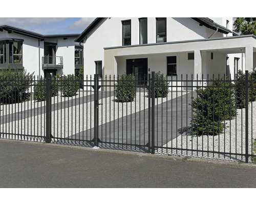 Svart metallstaketport framför ett bostadshus