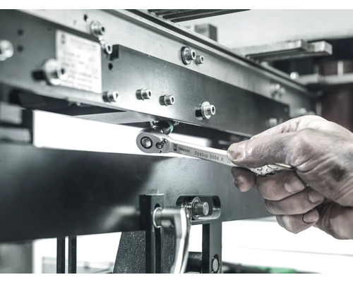 En arbetare använder en Wera Zyklop 8004 A ringnyckel för att dra åt en skruv på en metallkonstruktion.