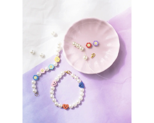 Pärlarmband med smileyberlocker och tillbehör på en tallrik