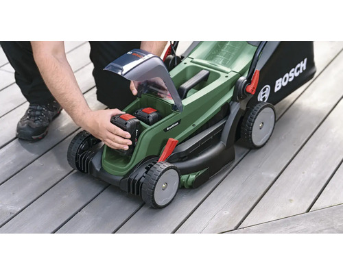 Överliggande vy av en gräsklippare där ett batteri sätts i